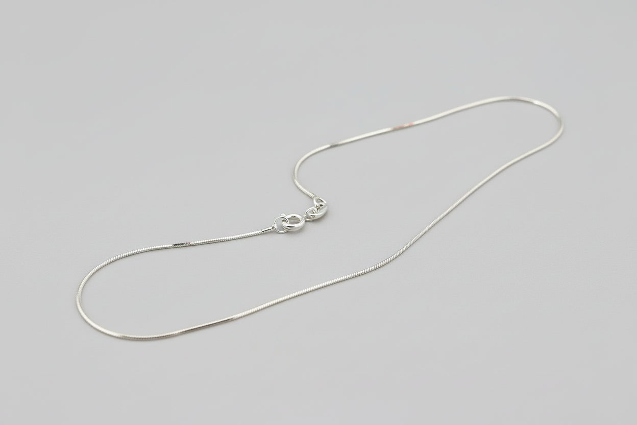 Silver necklace on a textured gray surface